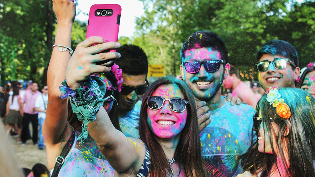 People taking selfie and enjoying colour festival
