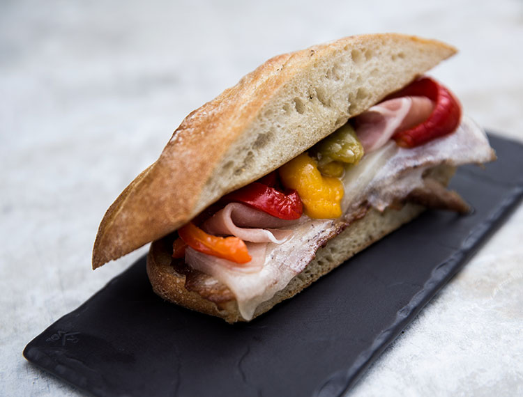 Tapas style sandwich of charred vegetables and ham served in the bar