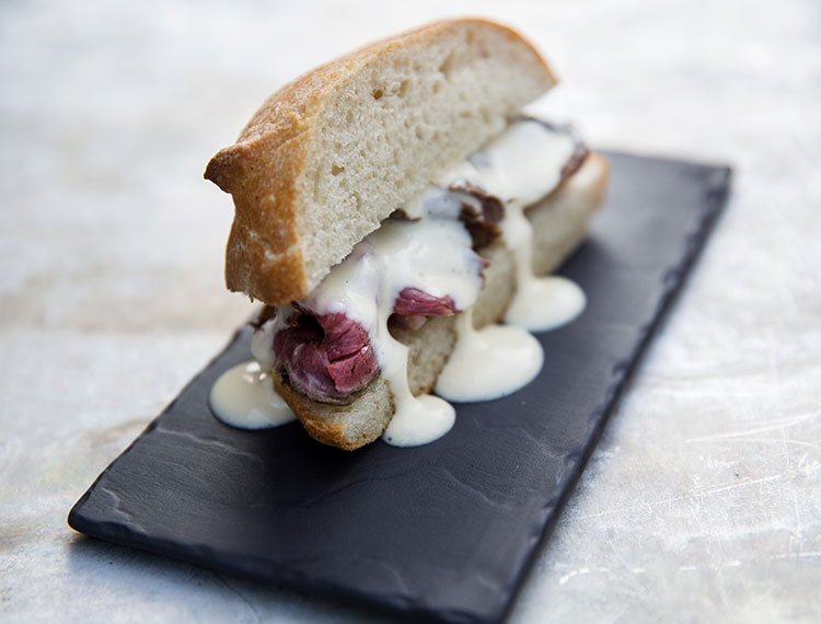 Tapas style sandwich of steak with cheese sauce served in the bar