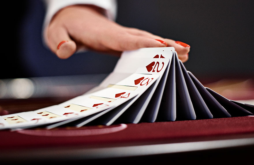 Casino dealer flipping branded playing cards